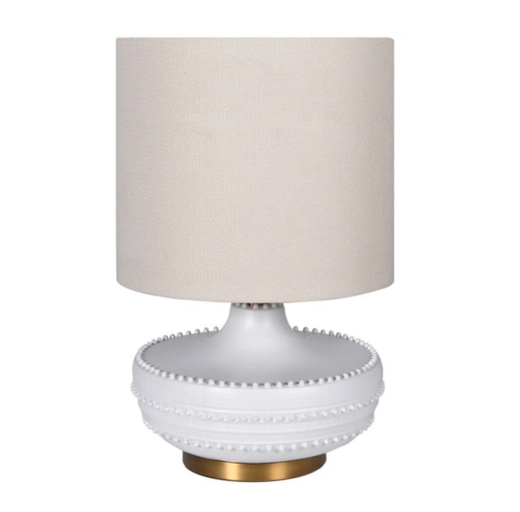 Table lamp with a white base and beige shade on a white background