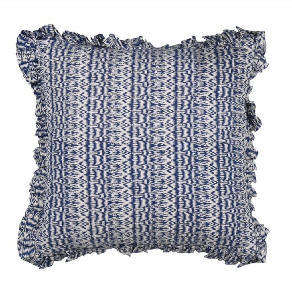 Decorative pillow with blue and white pattern and ruffled edges on a white background