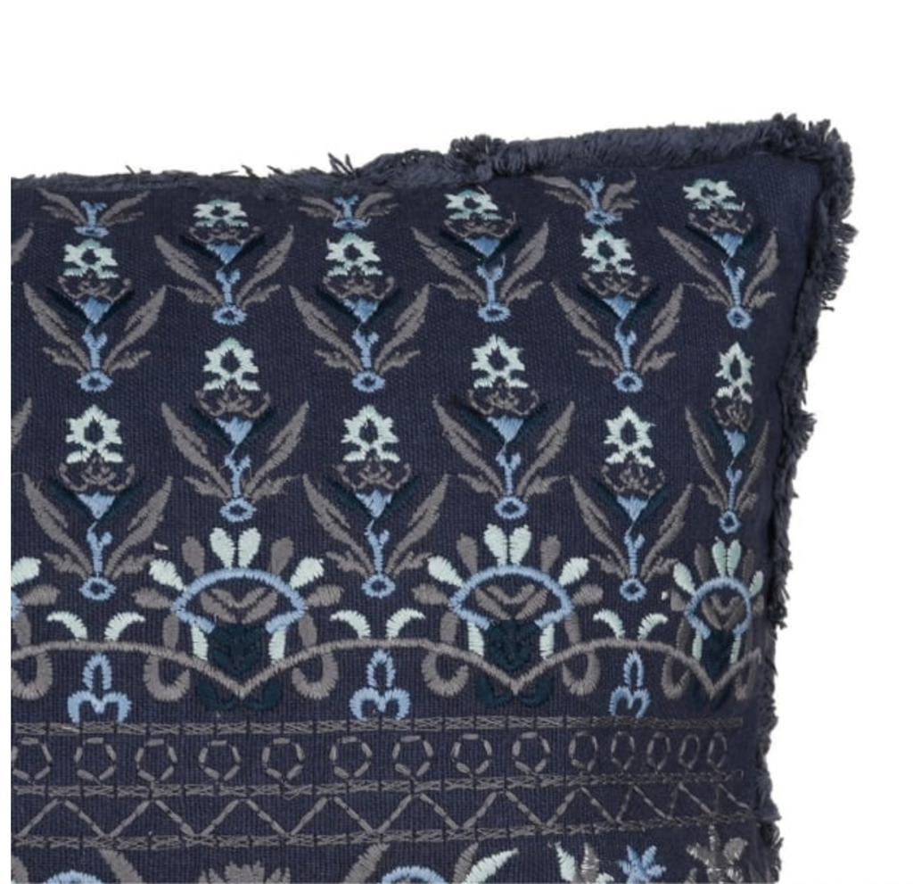 Navy blue pillow with intricate floral pattern on a white background