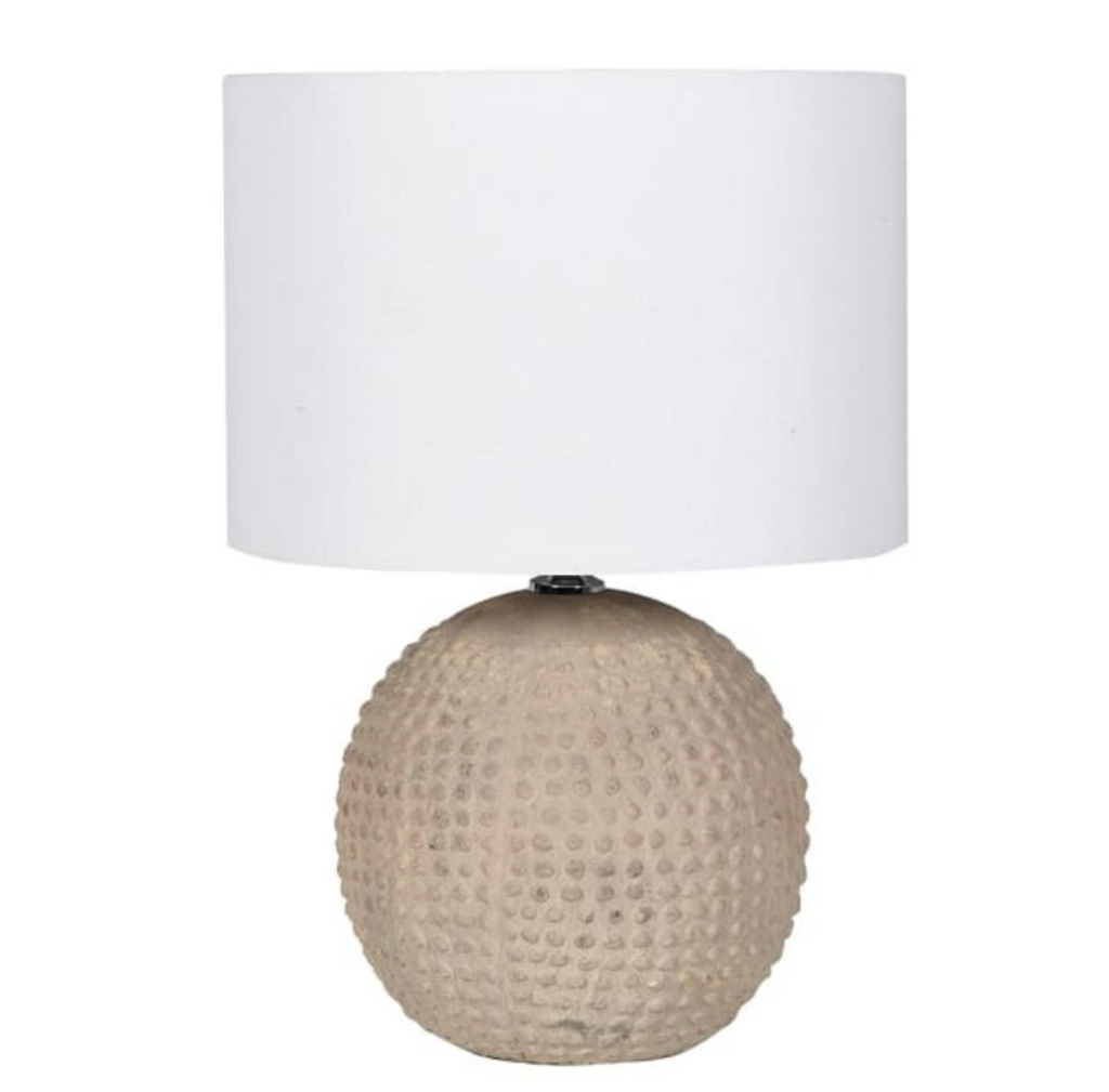 Table lamp with textured beige base and white shade on a white background