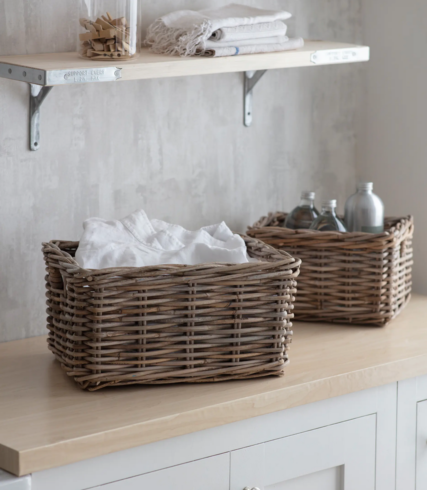 Two wicker baskets on a wooden surface with a neutral background