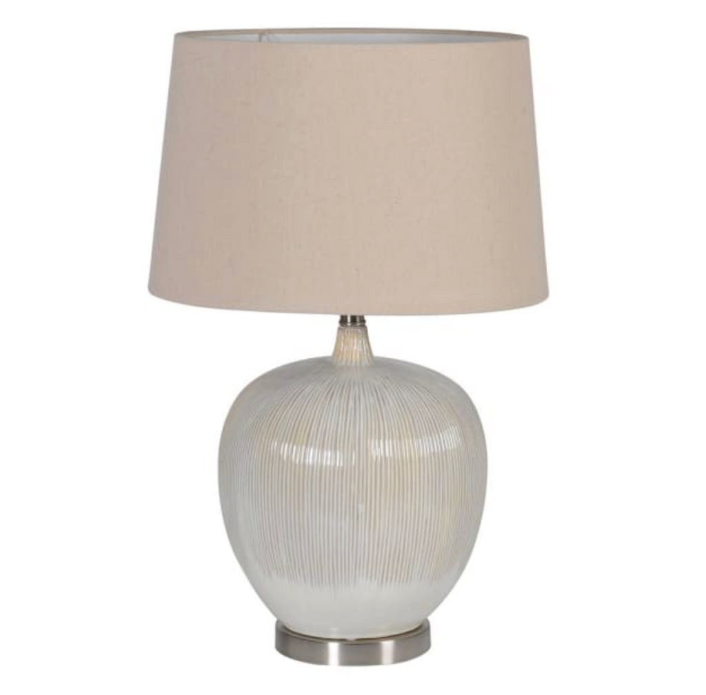 Table lamp with a textured white base and beige lampshade on a white background