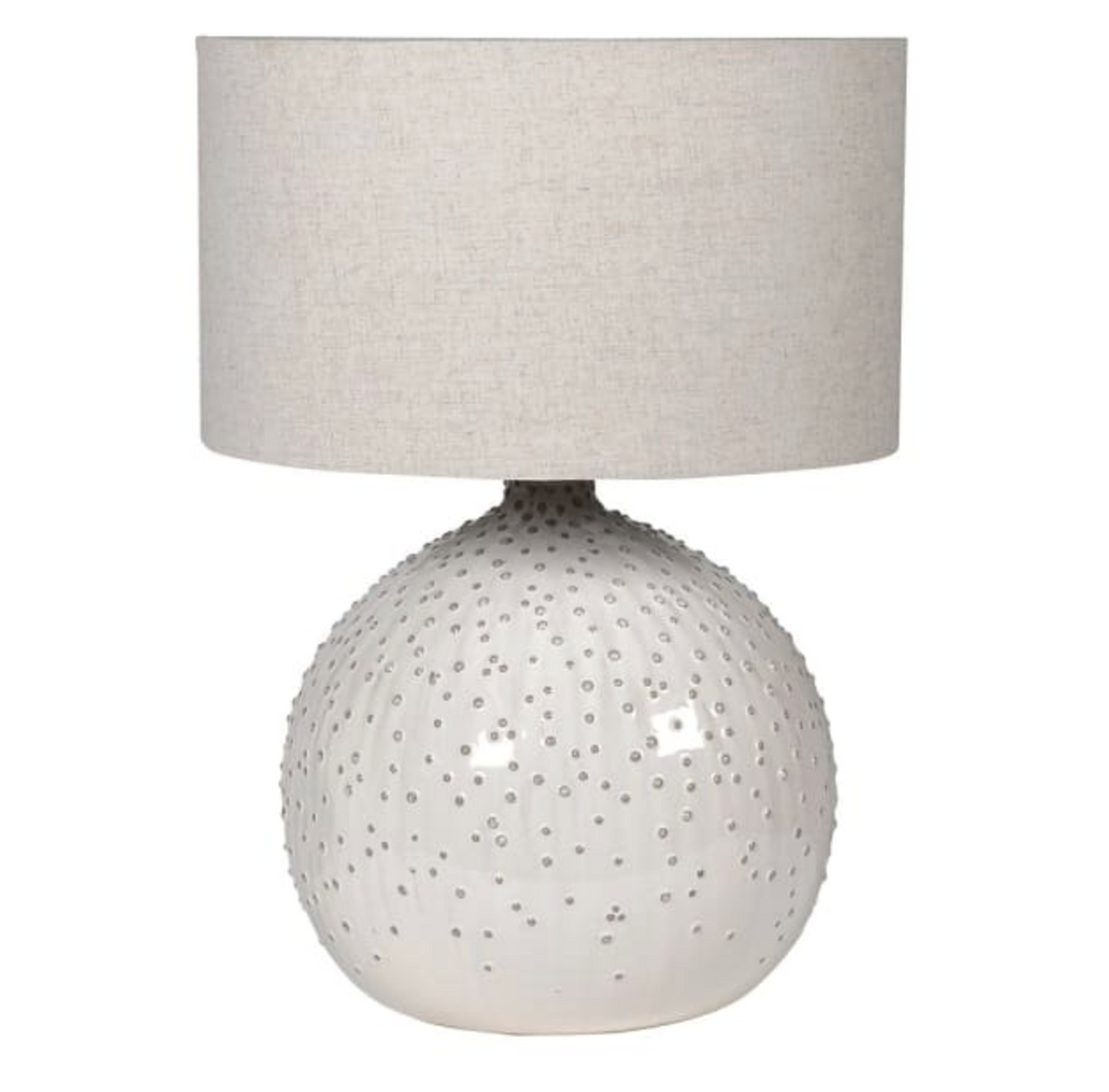 Table lamp with textured white base and gray fabric shade on a white background