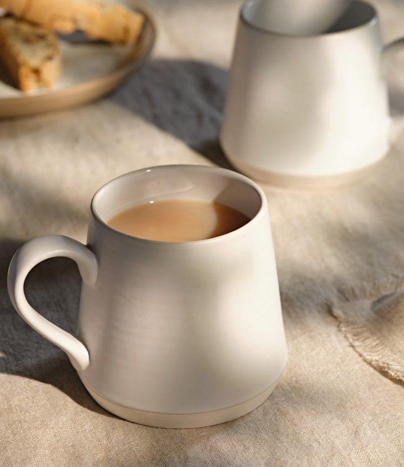 White ceramic mug with a drink on a textured surface