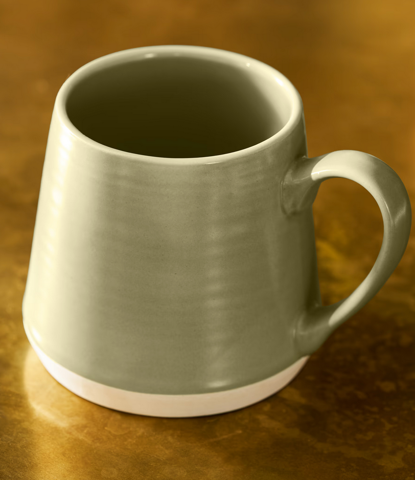 Green ceramic mug on a brown surface