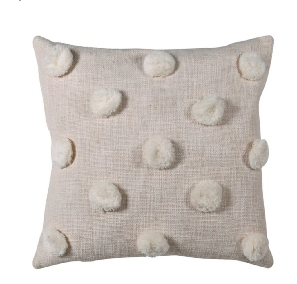 Beige pillow with white pom-poms on a white background