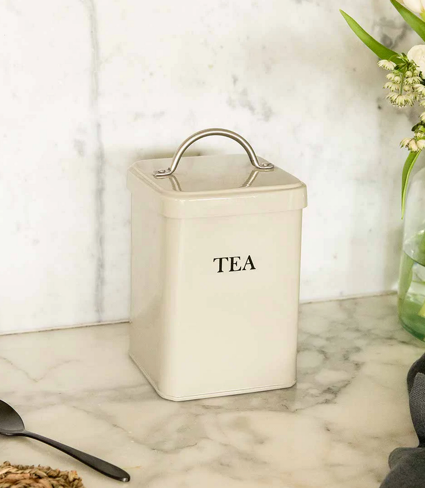 Beige tea canister with 'TEA' label on a marble surface