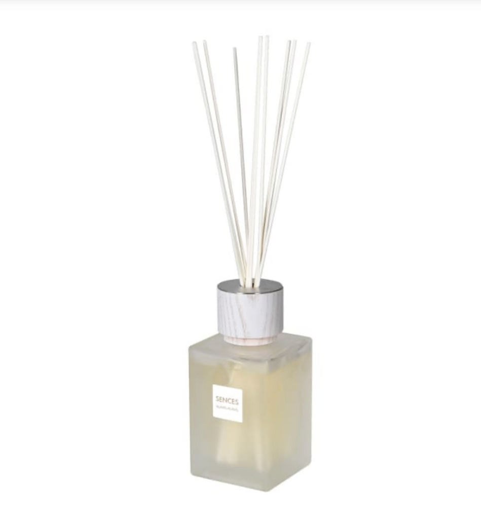 Square diffuser bottle with white reeds on a white background