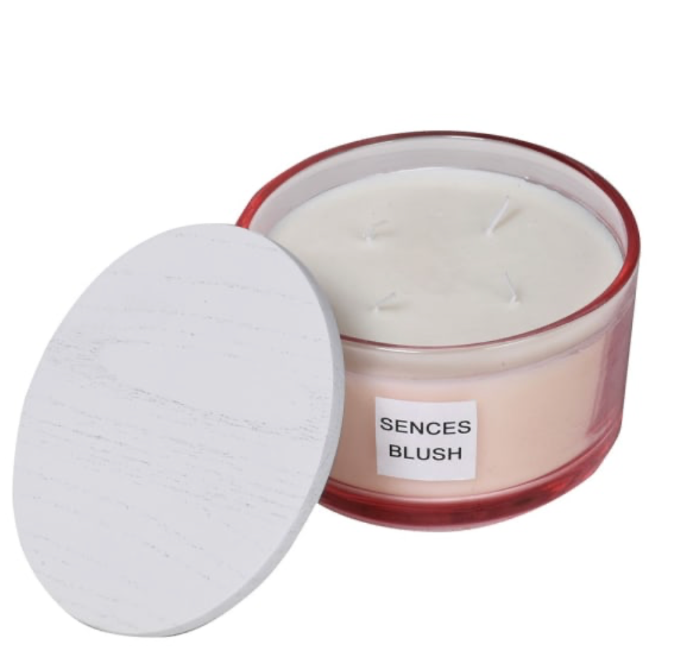 Candle in a jar labeled 'Sences Blush' with a white lid on a white background